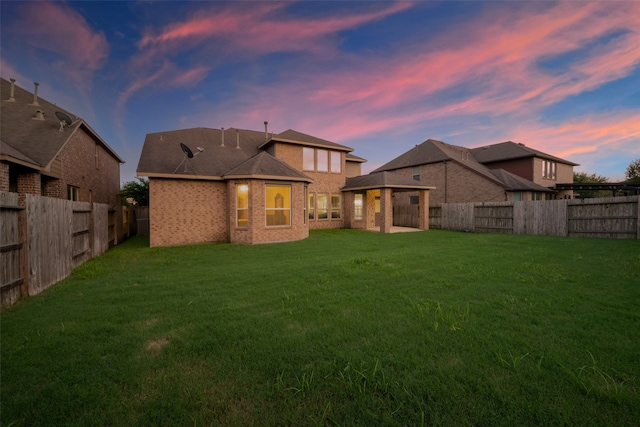 back house at dusk with a lawn and a gazebo