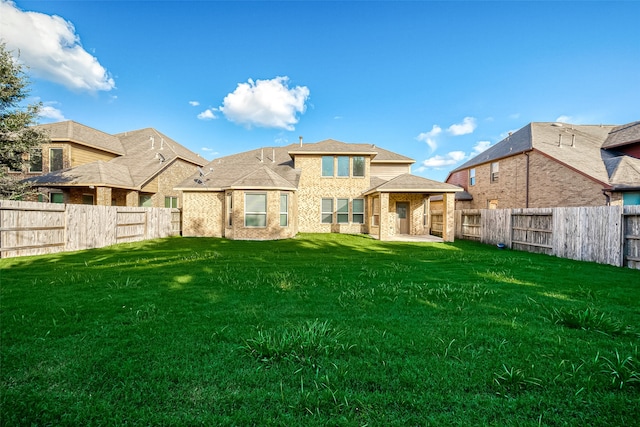 rear view of property with a lawn