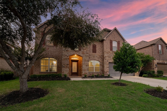 view of front of house featuring a garage and a lawn