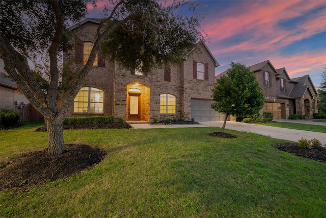 view of front of house with a yard and a garage