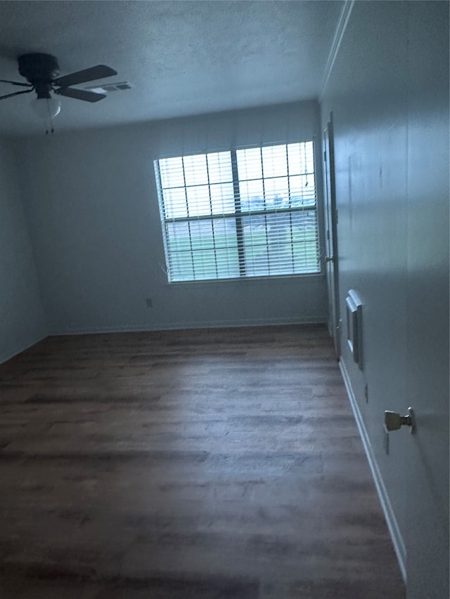 empty room featuring ceiling fan, wood-type flooring, and a textured ceiling