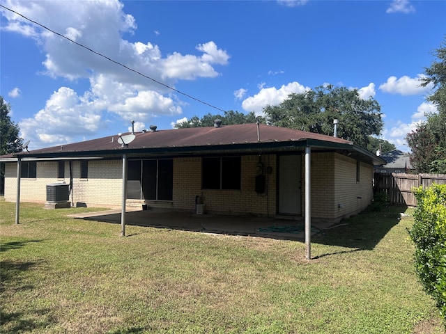 rear view of house featuring a patio area, a yard, and central AC