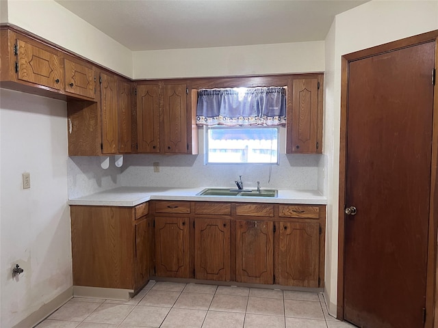 kitchen featuring decorative backsplash, light tile patterned floors, and sink