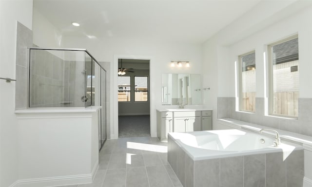 bathroom with tile patterned flooring, ceiling fan, separate shower and tub, and vanity