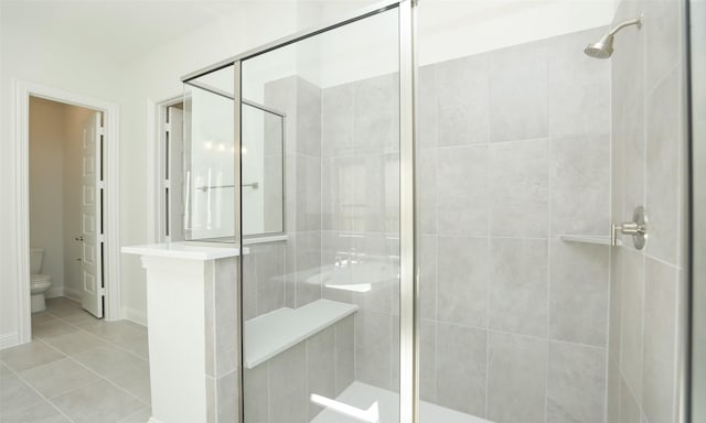 bathroom featuring tile patterned floors, an enclosed shower, and toilet