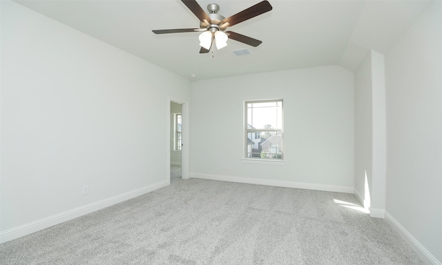 spare room featuring ceiling fan, light carpet, and vaulted ceiling