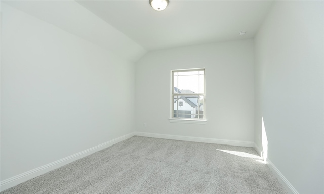 additional living space featuring light carpet and vaulted ceiling