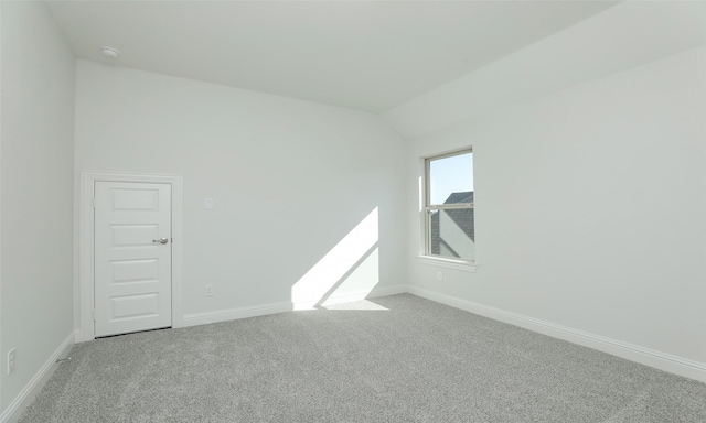 unfurnished room with light colored carpet and lofted ceiling