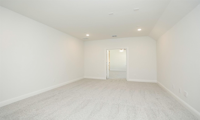 carpeted empty room featuring vaulted ceiling