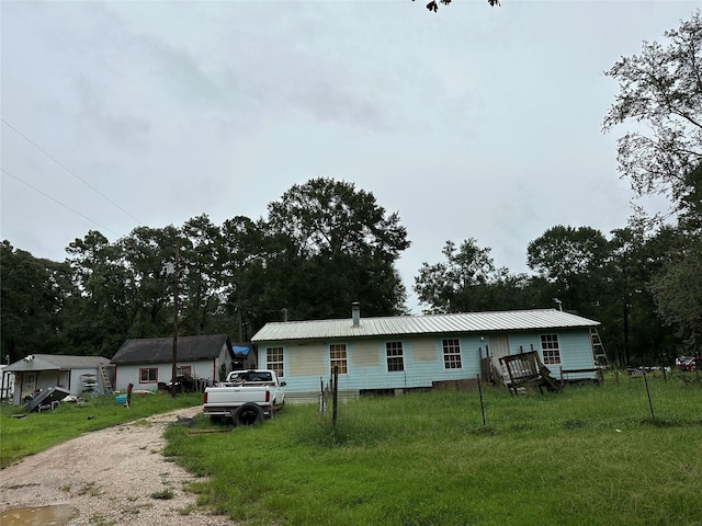 manufactured / mobile home featuring a front yard, metal roof, and driveway