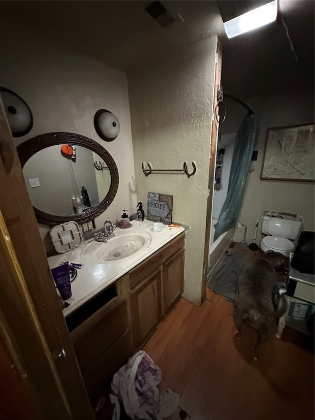 bathroom with vanity, hardwood / wood-style flooring, and toilet