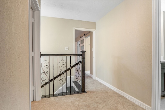 hall with carpet flooring and a textured ceiling