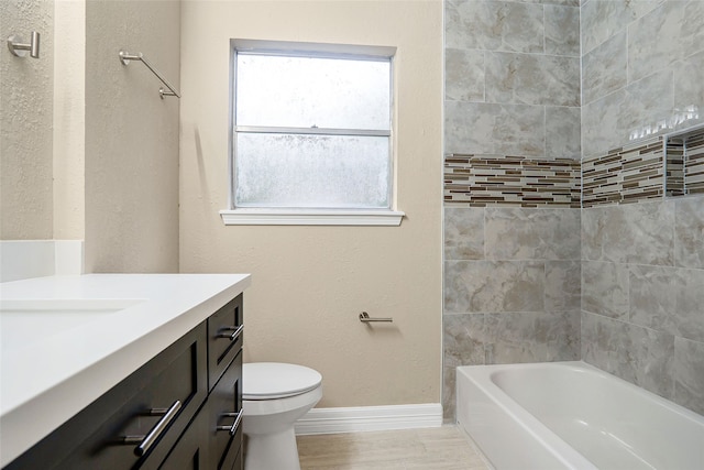 full bathroom featuring hardwood / wood-style floors, tiled shower / bath combo, toilet, and vanity