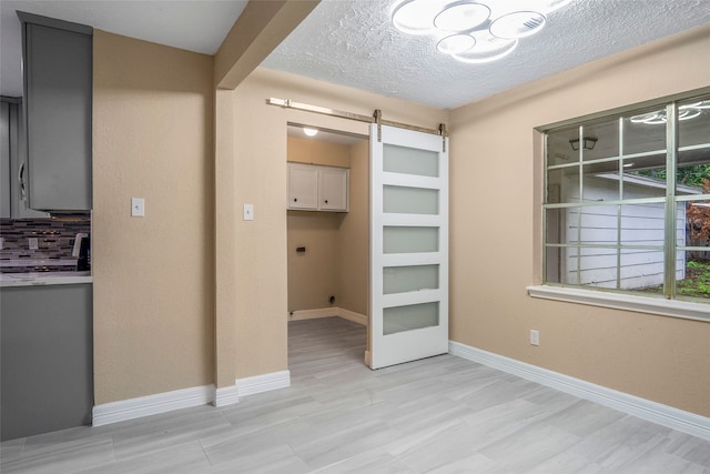 interior space featuring a barn door and a textured ceiling