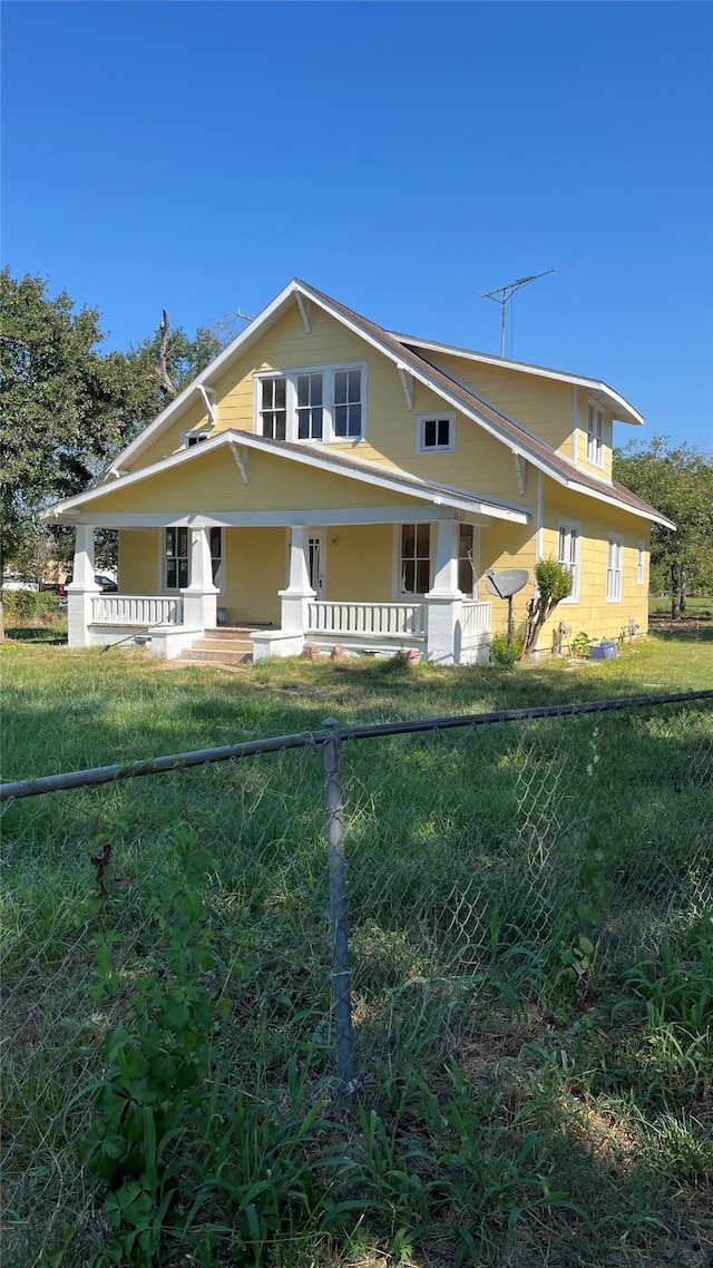 exterior space featuring covered porch and a front yard