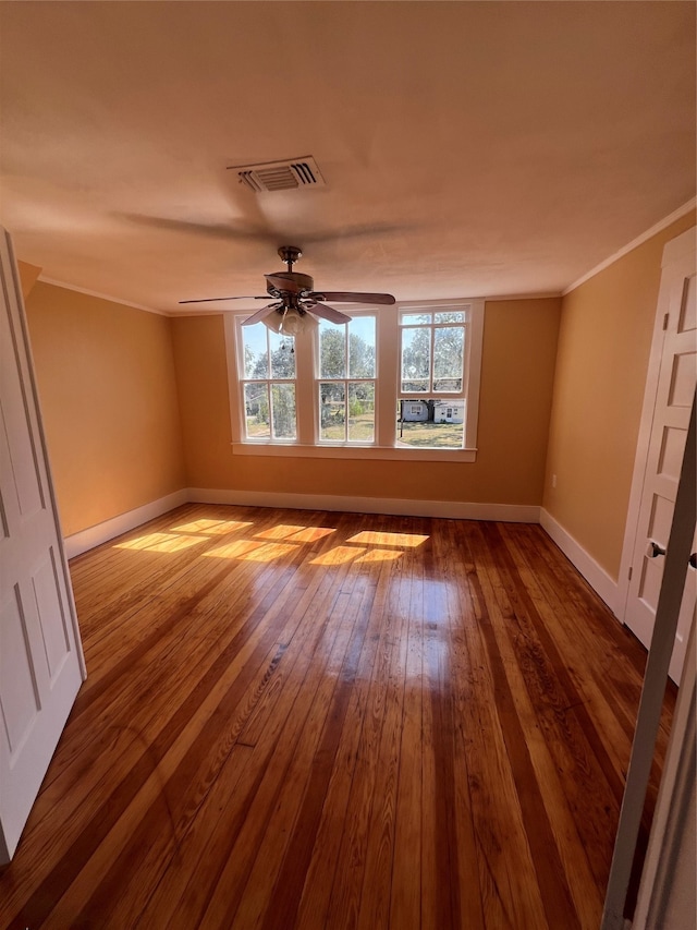 spare room with ceiling fan, wood-type flooring, and ornamental molding