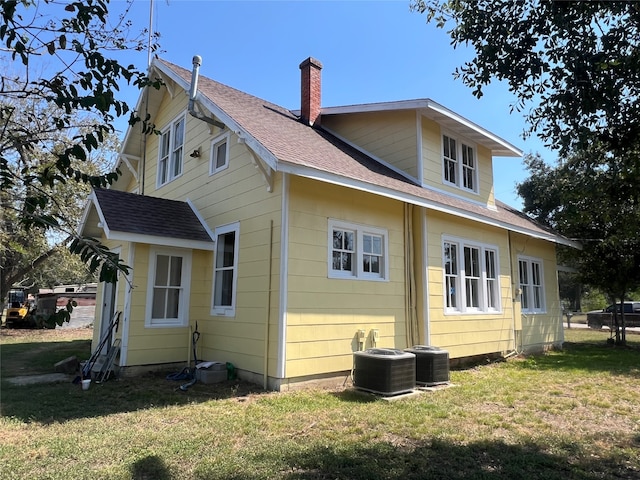 back of house featuring a yard and central AC