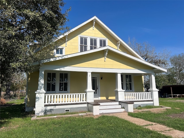 view of front of house featuring covered porch and a front lawn