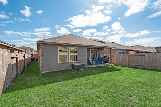 rear view of property with a patio and a lawn