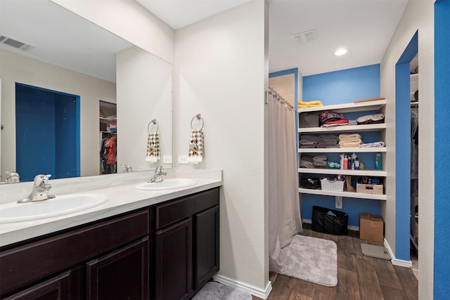 bathroom with double vanity and wood-type flooring