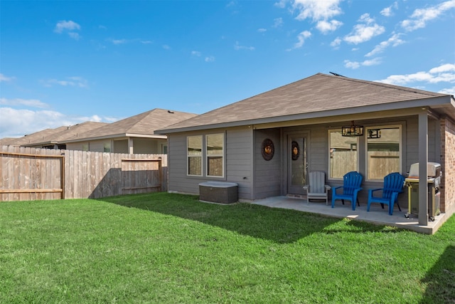 rear view of property with a patio and a lawn