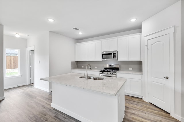 kitchen with white cabinetry, a kitchen island with sink, sink, and stainless steel appliances