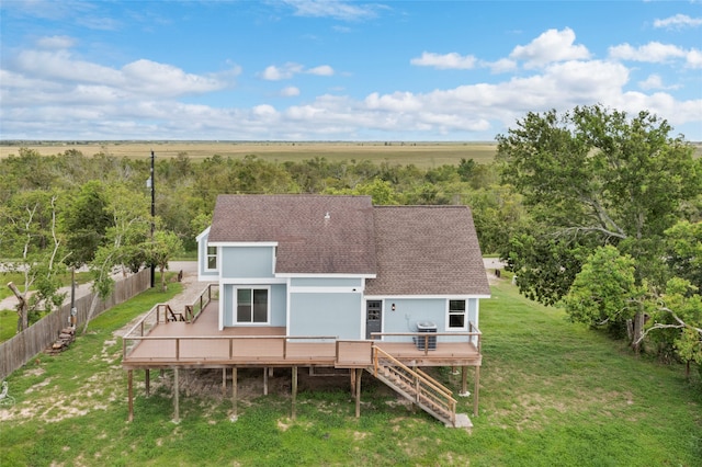 rear view of house featuring a yard, a rural view, and a deck