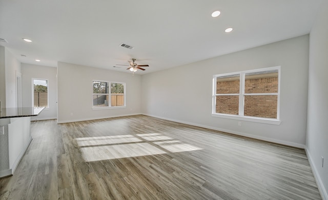 unfurnished living room with light hardwood / wood-style floors and ceiling fan