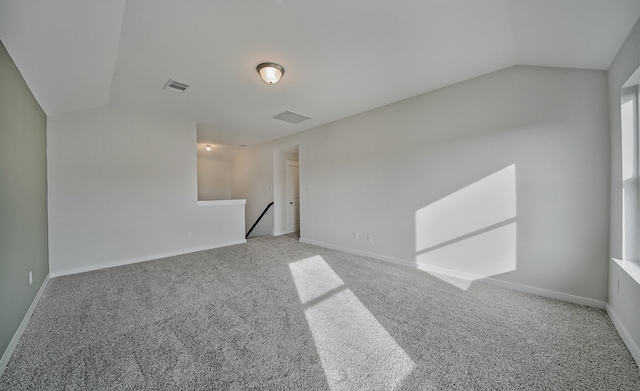 empty room with carpet floors and lofted ceiling