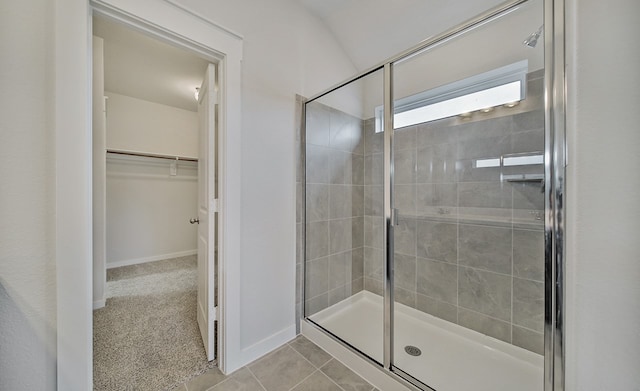 bathroom with a shower with shower door and tile patterned flooring