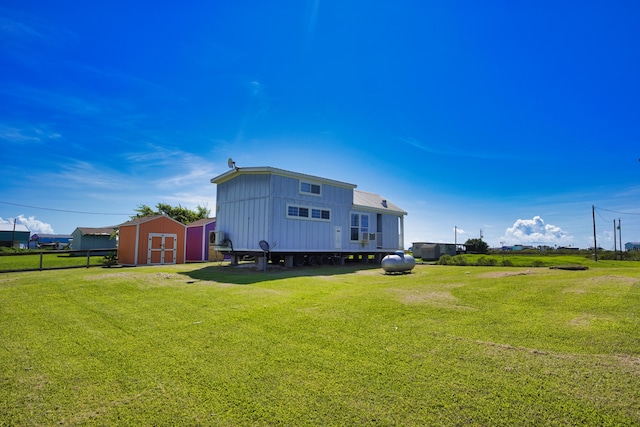 rear view of property featuring a storage shed and a yard