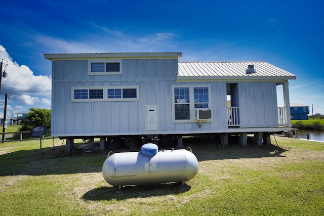 rear view of property featuring a lawn and a water view