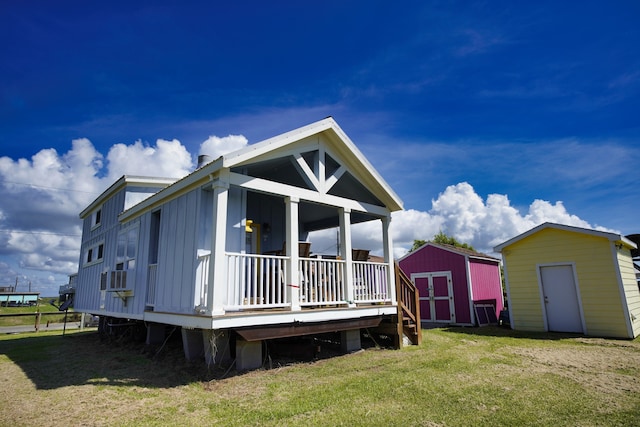 back of property featuring a storage shed and a yard