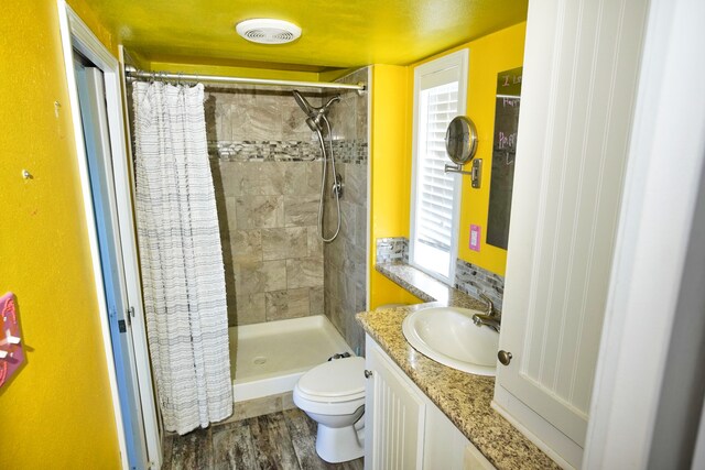 bathroom with hardwood / wood-style flooring, vanity, toilet, and a shower with curtain