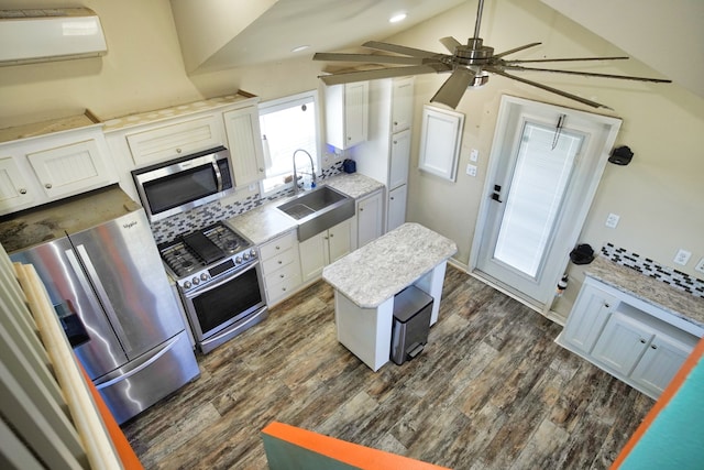 kitchen featuring white cabinetry, vaulted ceiling, stainless steel appliances, ceiling fan, and sink