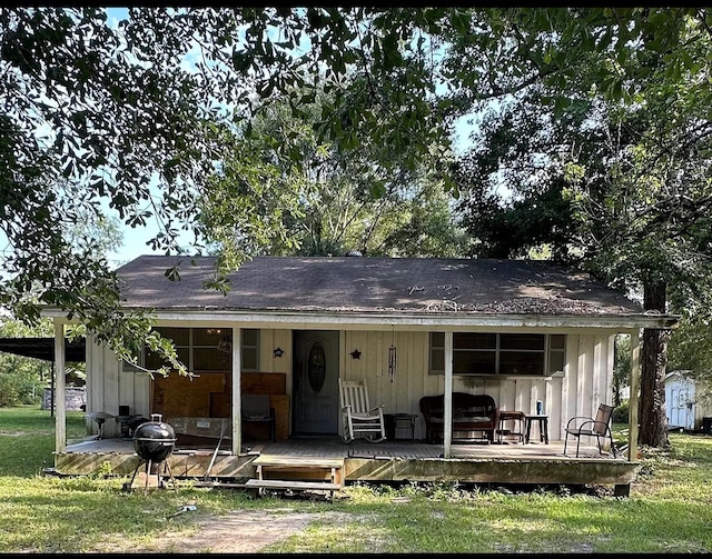 view of front of property with a wooden deck and a front lawn