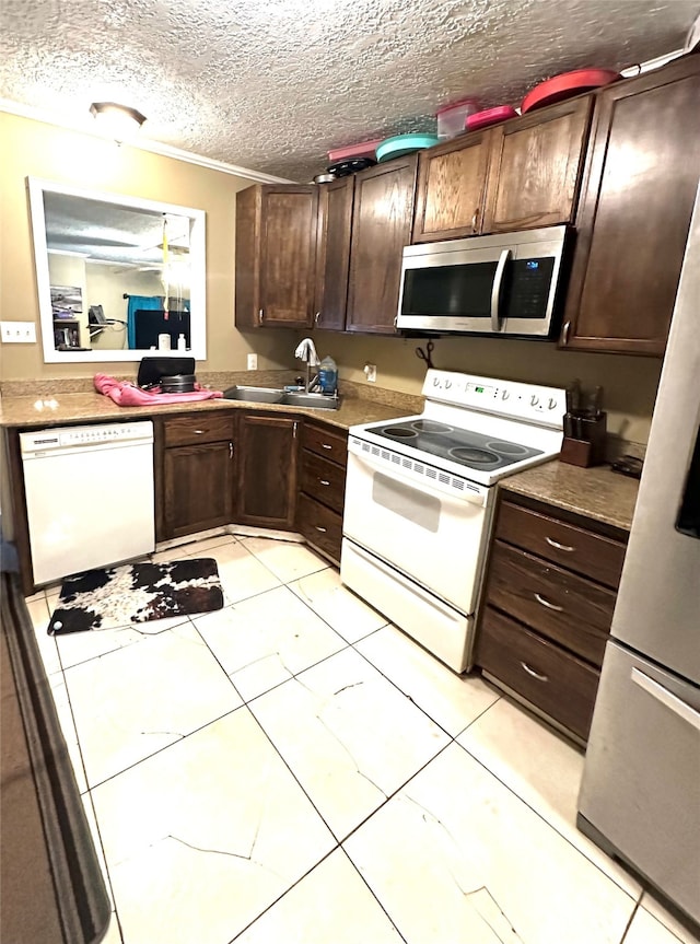 kitchen with dark brown cabinetry, appliances with stainless steel finishes, and sink