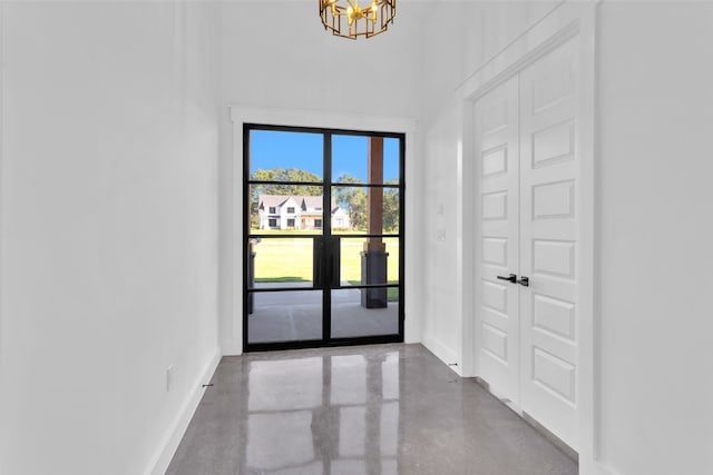 empty room with concrete flooring and a notable chandelier