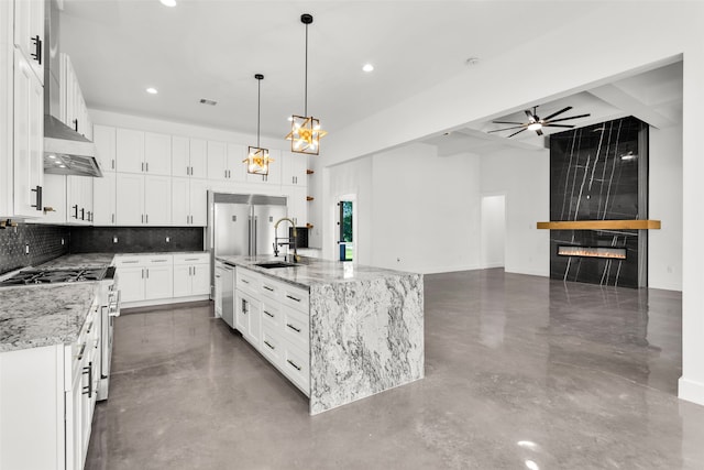 kitchen featuring pendant lighting, a kitchen island with sink, light stone counters, white cabinetry, and stainless steel appliances