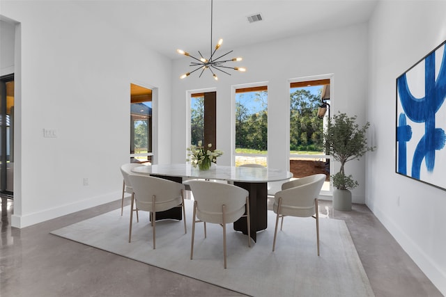 dining room featuring a chandelier and concrete floors