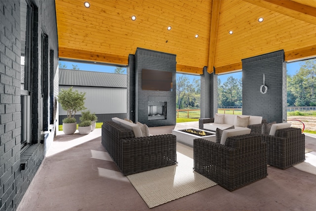 view of patio with an outdoor living space with a fireplace and a gazebo