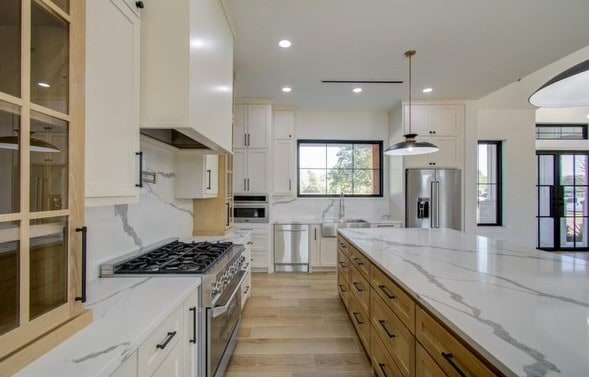 kitchen with white cabinetry, appliances with stainless steel finishes, and pendant lighting