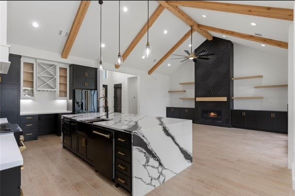 kitchen featuring a large island, beam ceiling, stainless steel appliances, and pendant lighting