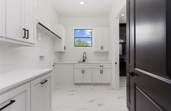 washroom with sink, washer hookup, and cabinets