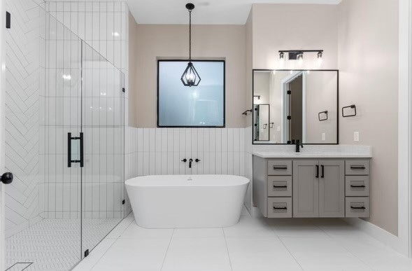 bathroom with tile walls, vanity, plus walk in shower, and tile patterned flooring