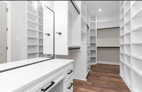 walk in closet with dark hardwood / wood-style flooring