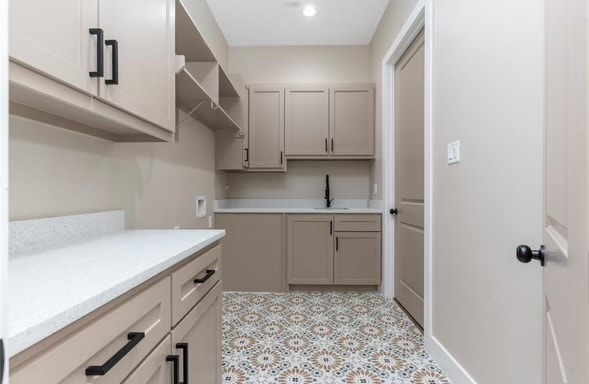 laundry room featuring sink, washer hookup, and cabinets