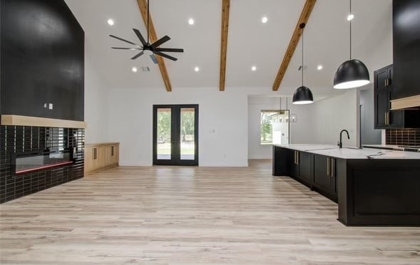 kitchen featuring beamed ceiling, decorative light fixtures, high vaulted ceiling, and a wealth of natural light