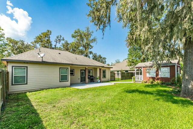 rear view of house featuring a patio and a yard