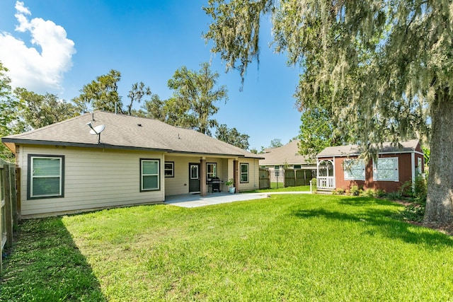 back of house with a yard and a patio area